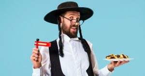 Young orthodox jewish man with hamantaschen cookies